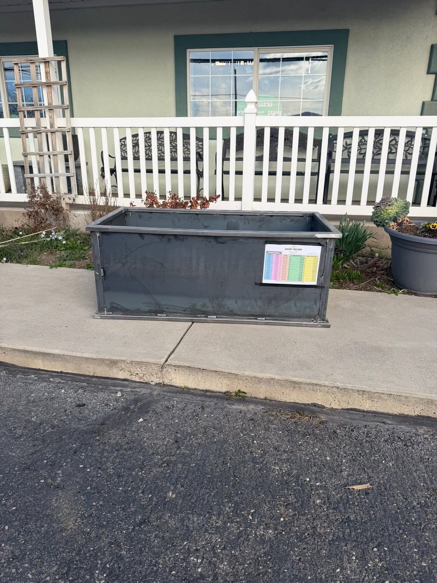 A finished bare-steel garden box on a sidewalk